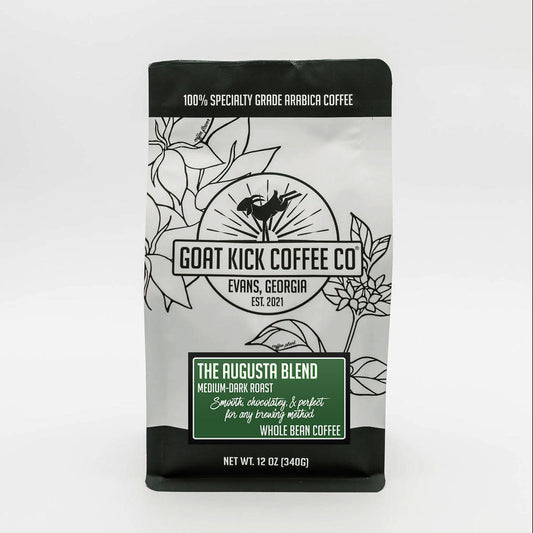 A 12 oz bag of Goat Kick Coffee Co. The Augusta Blend medium dark roast coffee, shown in a black and white illustrated package with a green label block, on a white background.